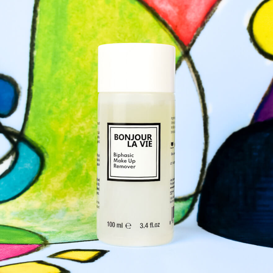 Image of the bottle of the biphasic makeup remover and part the Luca Maraldi paiting on the background, gree, blue and white. Immagine del flacone di struccante bifasico con dettaglio della tela di Luca Maraldi sullo sfondo, nei toni del verde, blu e bianco