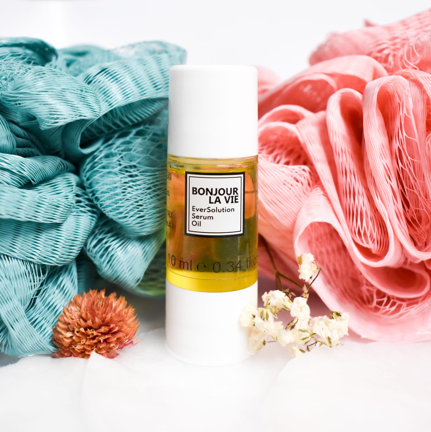 Light_Ever30ml_square 2717 × 2717px Immagine del flacone di eversolution Serum Oil tra due tessuti, uno rosa e uno azzurro