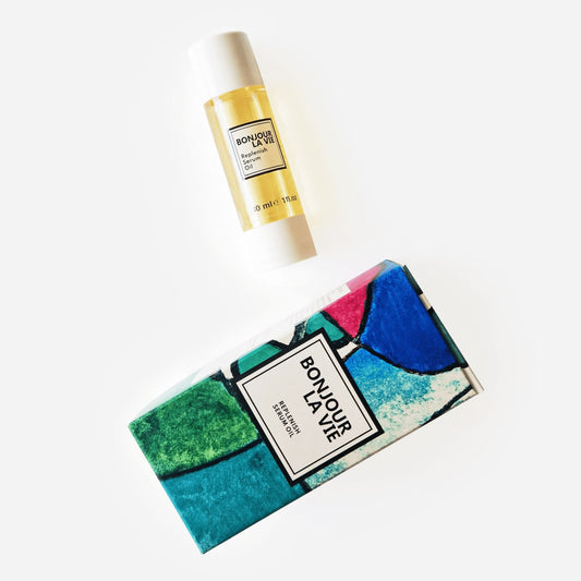 Immagine su fondo bianco del flacone e della scatola colorata sui toni di blu, verde e  una punta di rosso di Replenish Serum Oil da 30 ml di Bonjour La Vie