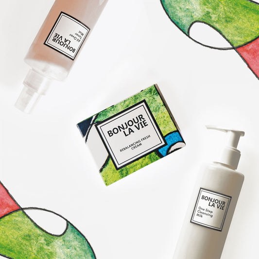 Immagine dei tre prodotti di Bonjour La Vie che compongono la Routine per pelli delicate ovvero All Over Toner Mist, Rebalancing Fresh Cream e One Step Cleansing Milk su fondo bianco con due elementi decorativi