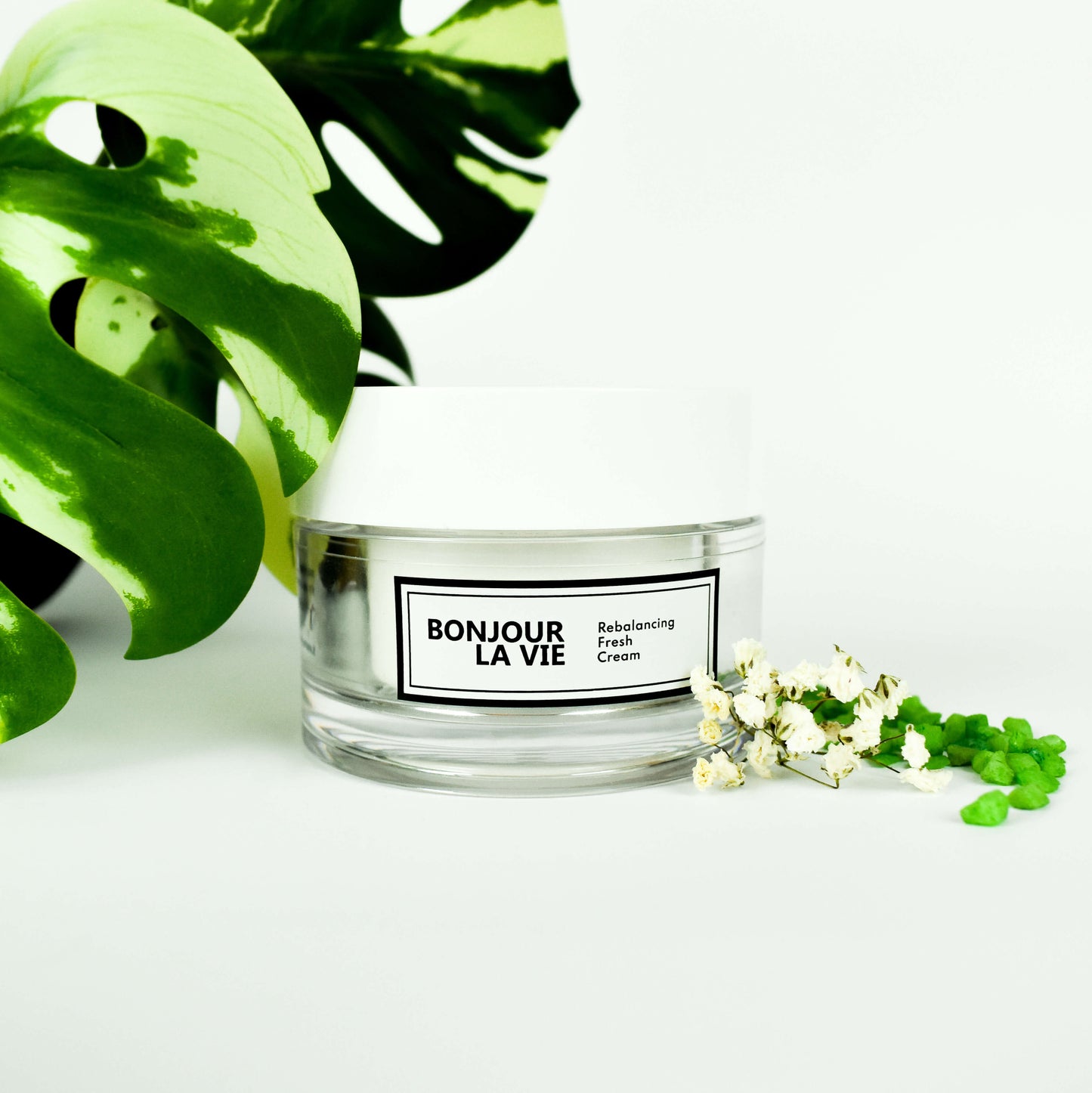 Immagine della Rebalancing Fresh cream con una foglia e qualeche fiorellino sui toni del bianco e verde