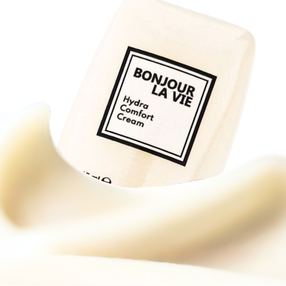 Primo piano della texture di Hydra Comfort Cream di Bonjour La Vie in evidenza davanti al flacone.